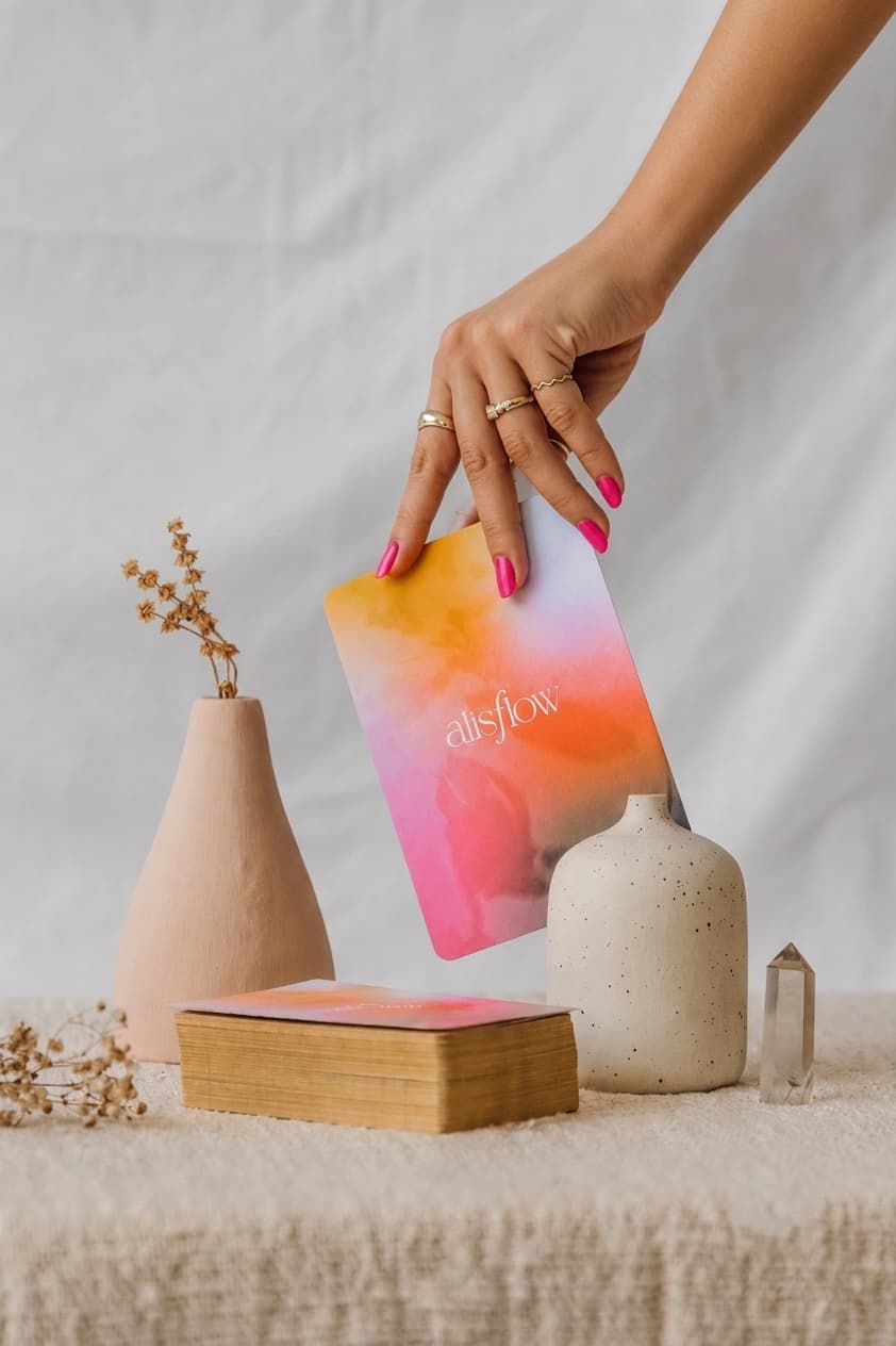 Cartas del Oráculo Esentia sobre una mesa con jarrones y un cuarzo