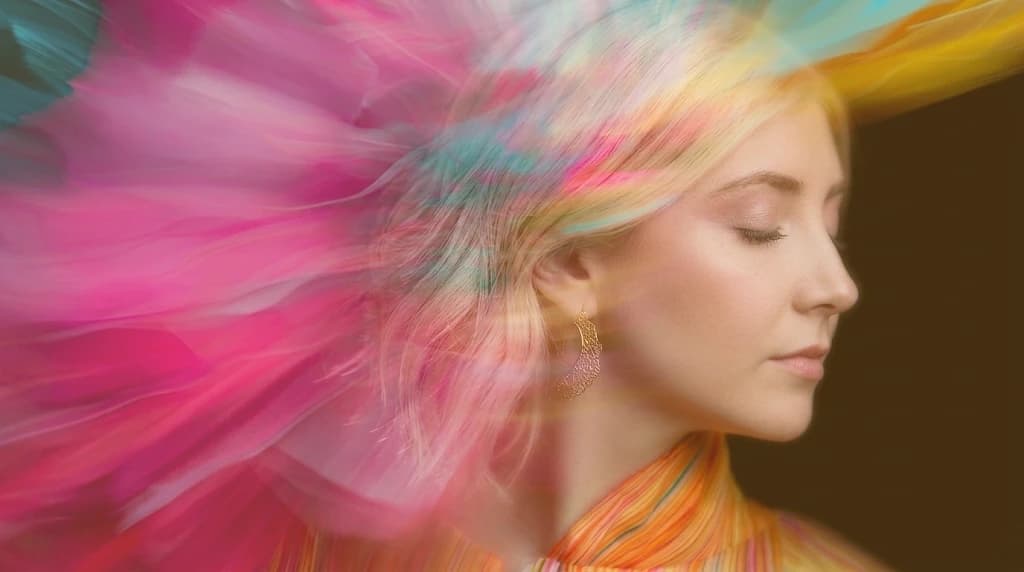 Mujer con los ojos cerrados, envuelta en color en movimiento